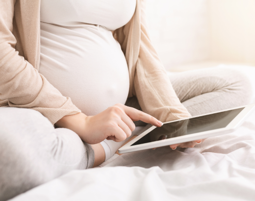 Mulher lendo livros para grávidas em seu período de gestação