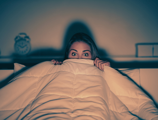 mulher assustada assistindo a um filme de Halloween