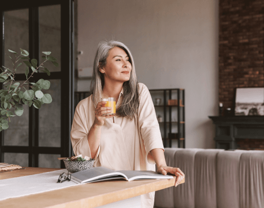 Mulher madura reflexiva ao ler livros sobre empoderamento feminino