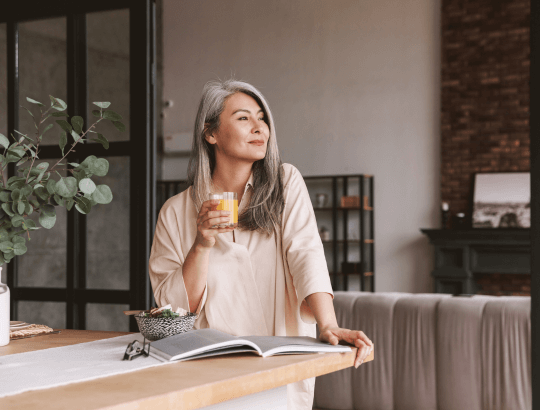 Mulher madura reflexiva ao ler livros sobre empoderamento feminino